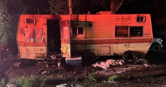 Photo by Central Whidbey Island Fire and Rescue
Two people were trying to get their vehicle running on Central Whidbey when it caught fire Friday night, igniting a nearby trailer where they lived.