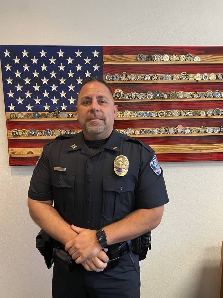 Captain Kevin Barton stands in front of an artistic rendering of the United States flag after getting onboarded to the Oak Harbor Police Department last June (Photo by Jessie Stensland)